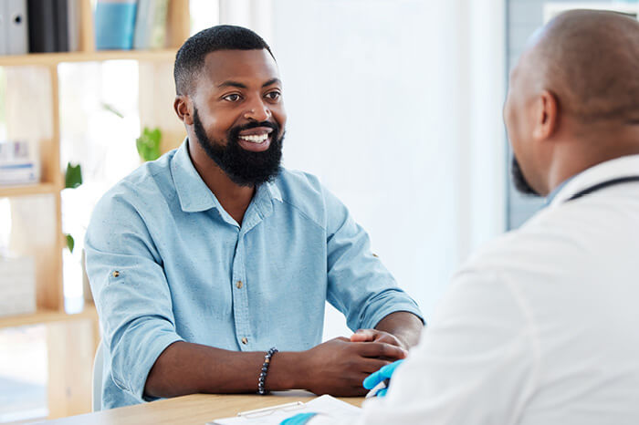 African American man in blue shirt talking with a doctor about PEP