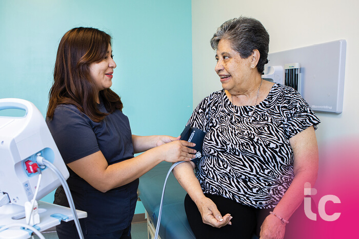 Medical Assistant taking a senior woman's blood pressure in doctor's office