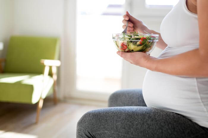 Portrait of pregnant woman eating healthy food