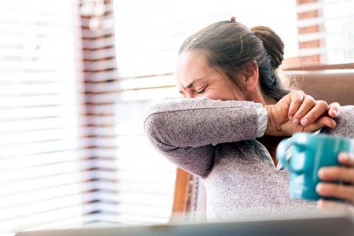 truecare-woman-coughing-featured-image-blog-700×466 Woman coughs into elbow working form home