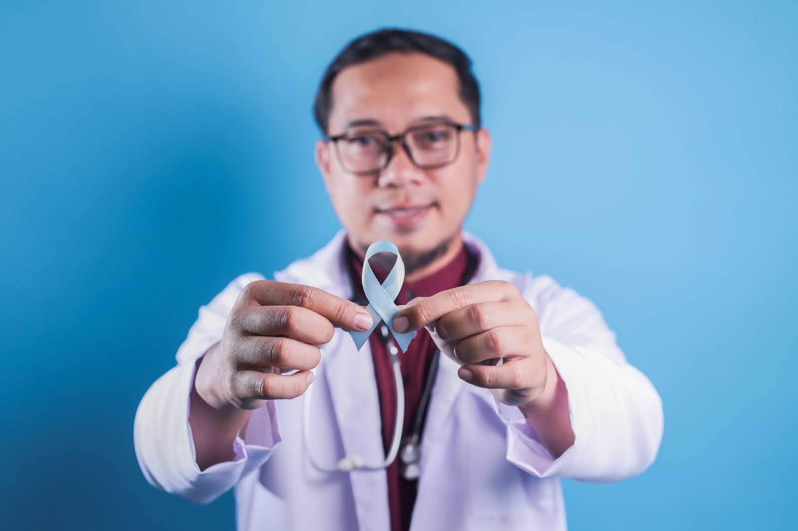 Doctor holding blue ribbon for diabetes awareness month