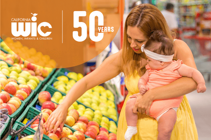 WIC 50th blog image 700×466 (1) Mom shopping for fruit with baby at market